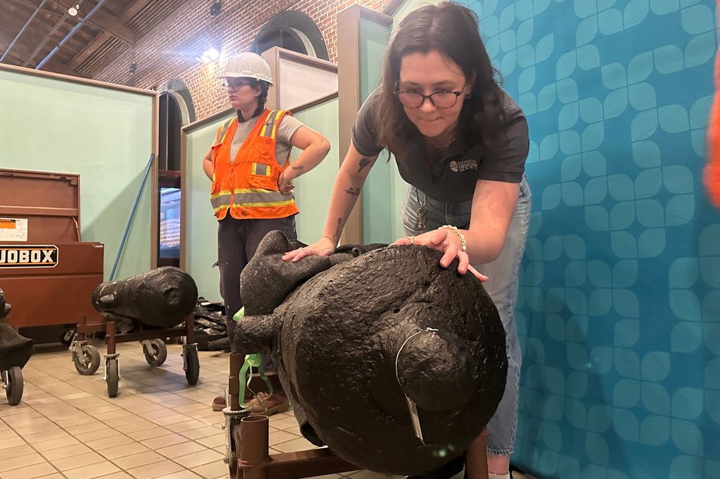 Samantha Moss inspects a cannon, which sunk to the bottom of the Savannah River during the American Revolution, at the Savannah History Museum in Savannah, Ga., on Wednesday, June 3, 2026. (AP Photo/Russ Bynum)