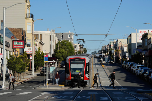 People cross Taraval Street after exiting a MUNI train in the Sunset District, Friday, Oct. 17, 2025, in San Francisco. (AP Photo/Godofredo A. Vásquez) People cross Taraval Street after exiting a MUNI train in the Sunset District, Friday, Oct. 17, 2025, in San Francisco. (AP Photo/Godofredo A. Vásquez)
