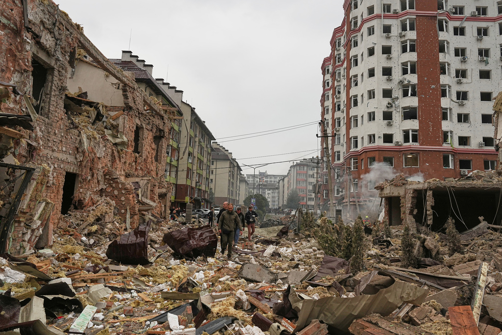 People walk near apartment buildings damaged after a Russian attack in Kyiv, Ukraine, Sunday, Sept. 28, 2025. (AP Photo/Efrem Lukatsky)
