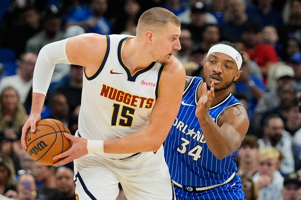 Denver Nuggets center Nikola Jokic (15) looks for a way around Orlando Magic center Wendell Carter Jr. (34) during the first half of an NBA basketball game, Saturday, Dec. 27, 2025, in Orlando, Fla. (AP Photo/John Raoux)