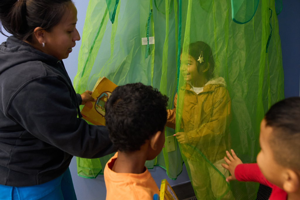 Celenia Romero reads to her Prek-5 students as they play in the library at CentroNia in Washington, Tuesday, Dec. 9, 2025. (AP Photo/Jacquelyn Martin)