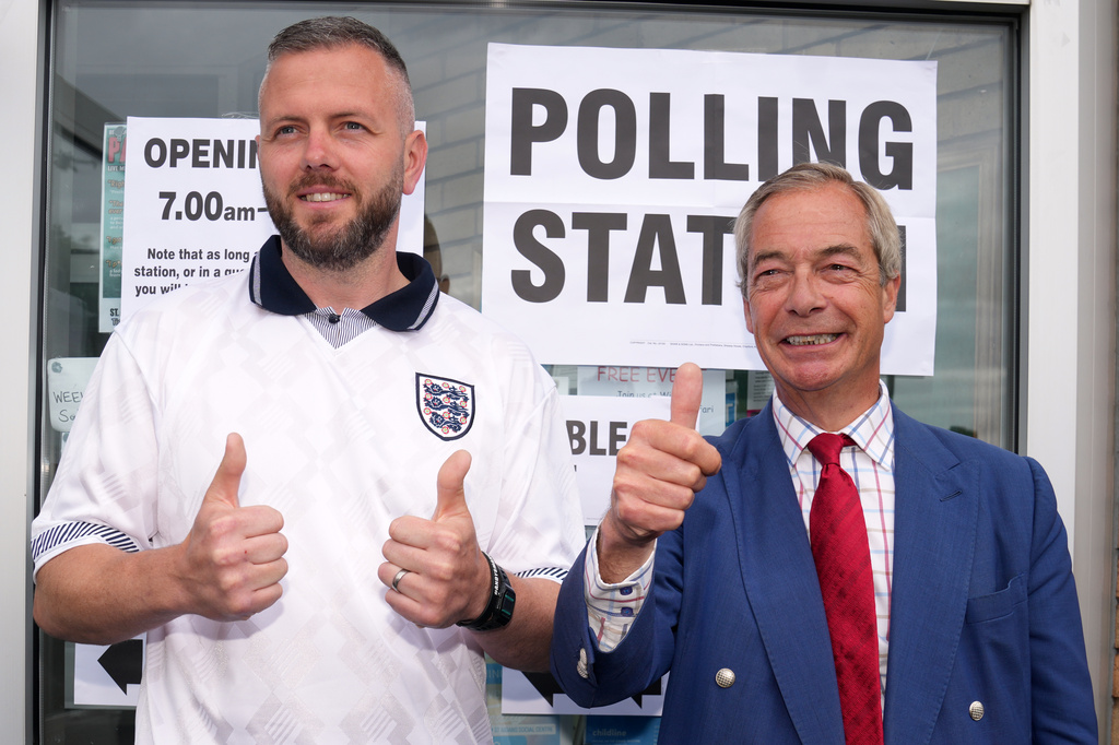 Britain's Reform Party leader Nigel Farage and local candidate Rob Kenyon flash a thumbs up at a polling station fduring the by-election in Makerfield, England, Thursday, June 18, 2026.(AP Photo/Jon Super)