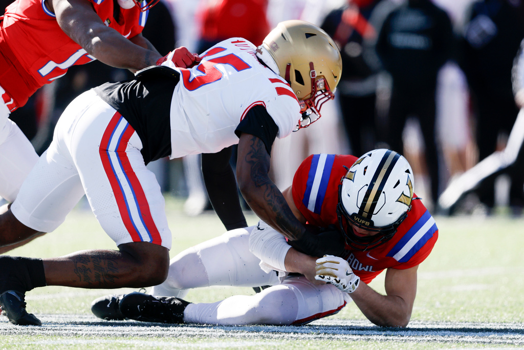 National Team quarterback Diego Pavia, bottom, of Vanderbilt, is sacked by American Team defensive end Quintayvious Hutchins (15), of Boston College, during the first half of the Senior Bowl NCAA college football game Saturday, Jan. 31, 2026, in Mobile, Ala. (AP Photo/Butch Dill)