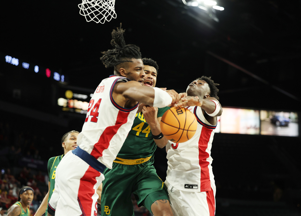 St. John's forward Zuby Ejiofor (24) and guard Joson Sanon (3) compete for a rebound with Baylor center Caden Powell (44) during the first half of an NCAA college basketball game Tuesday, Nov. 25, 2025, in Las Vegas. (AP Photo/Ronda Churchill)