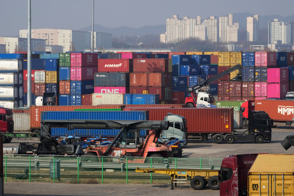 Trucks run by containers at the Uiwang ICD Terminal in Uiwang, South Korea, Thursday, March 12, 2026. (AP Photo/Ahn Young-joon)