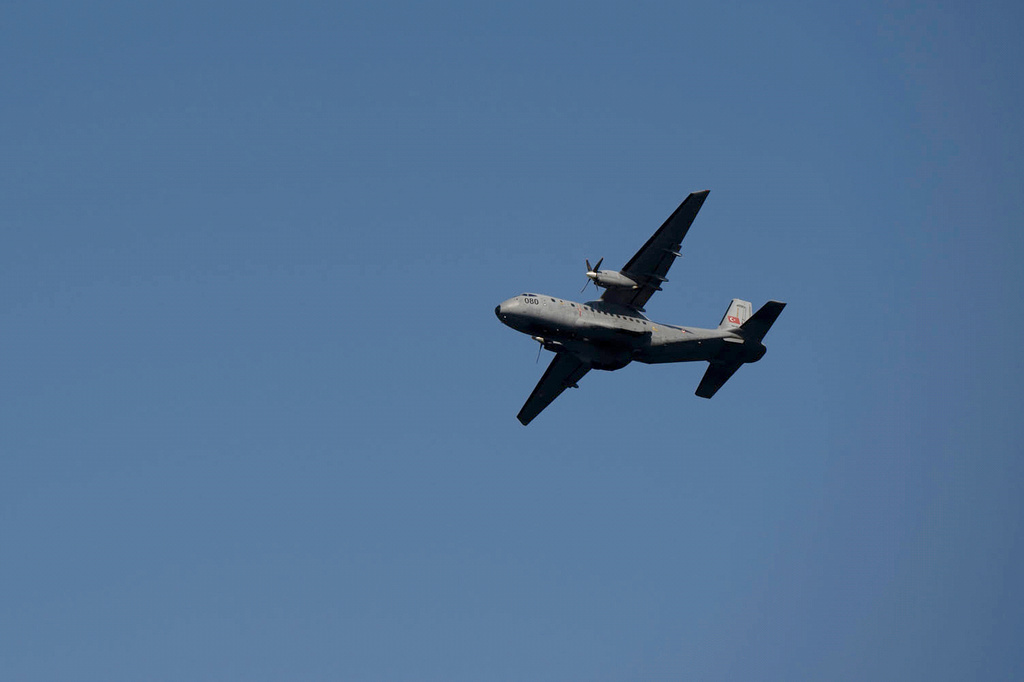 An aircraft flies over the port of Kyrenia in the Turkish-occupied northern part of Cyprus, Sunday, Aug. 30, 2026, after a catamaran-style ferry overturned off the island's northern coast. (AP Photo/Nedim Enginsoy)