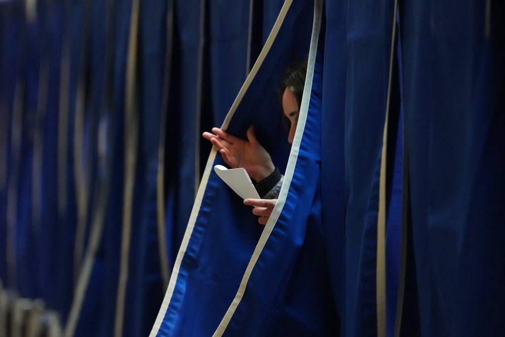 A person exits a polling booth at a polling station at City Hall in Copenhagen, Denmark, on Tuesday, March 24, 2026, during the general election. (AP Photo/Sergei Grits)