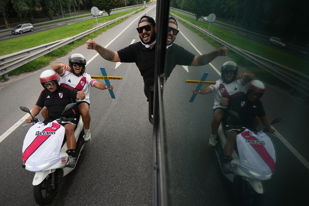 River Plate fans ride a bus followed by motorcycles on their way to the stadium for an Argentine league match against Boca Juniors in Buenos Aires, Argentina, Sunday, April 19, 2026. (AP Photo/Rodrigo Abd)