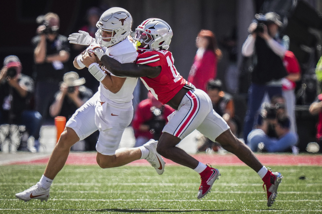 Texas quarterback Arch Manning (16) runs the ball as Ohio State safety Jaylen McClain (18) makes a tackle in the first half of an NCAA college football game in Columbus, Ohio, Saturday, Aug. 30, 2025. (Sara Diggins/Austin American-Statesman via AP)