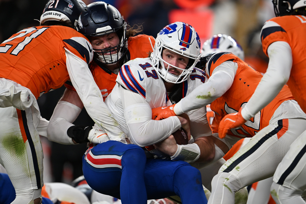 Buffalo Bills quarterback Josh Allen (17) runs for a first down during the second half an NFL divisional round playoff football game against the Denver Broncos, Saturday, Jan. 17, 2026, in Denver. (AP Photo/RJ Sangosti)
