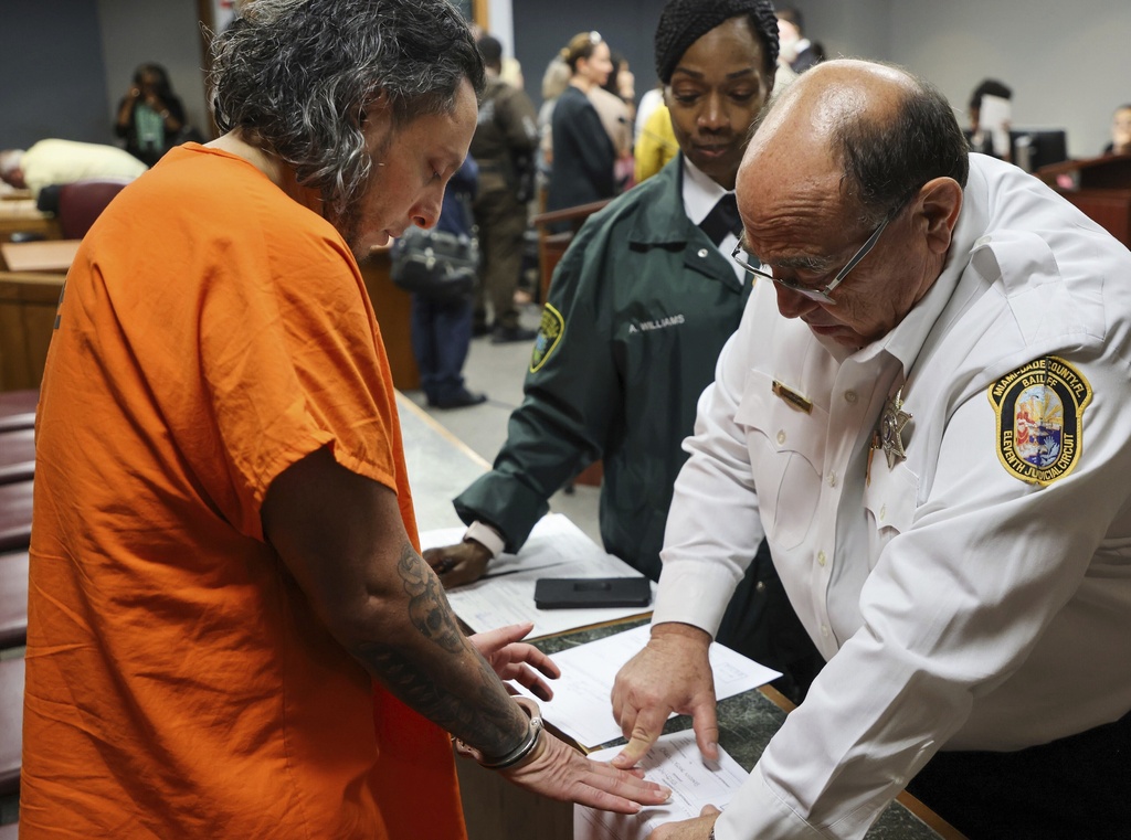 Oscar Olea, left, is fingerprinted after accepting the plea deal inside the Richard E. Gerstein Justice Building on Thursday, Aug. 21, 2025, in Miami, Fla. (Carl Juste/Miami Herald via AP, Pool)