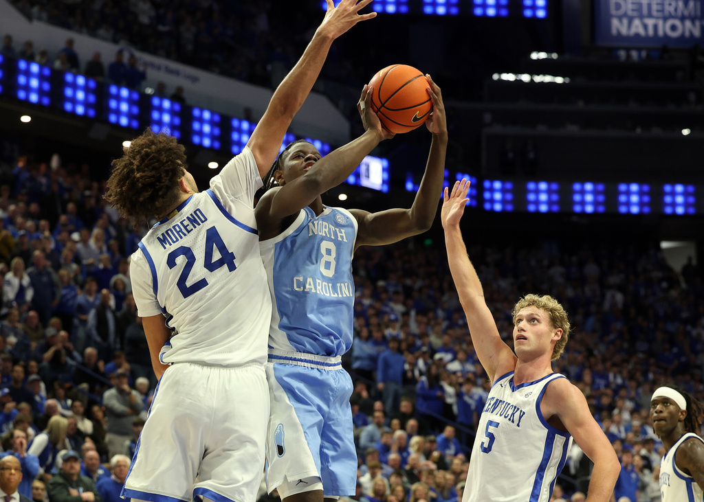 North Carolina's Caleb Wilson (8) shoots between Kentucky's Malachi Moreno (24) and Collin Chandler (5) during the second half of an NCAA college basketball game in Lexington, Ky., Tuesday, Dec. 2, 2025. (AP Photo/James Crisp)