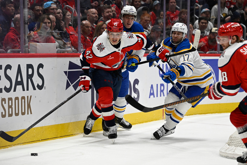 Washington Capitals defenseman Martin Fehérváry (42) chats the puck against Buffalo Sabres left wing Jason Zucker (17) during the second period of an NHL Hockey game, Saturday, April 4, 2026, in Washington. (AP Photo/John McDonnell)
