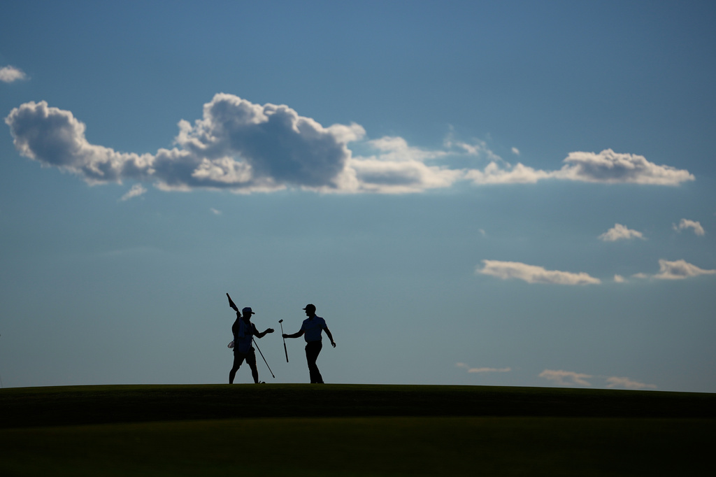 Wyndham Clark hands his club to his caddie on the 10th hole during the third round of the U.S. Open golf tournament at Shinnecock Hills Golf Club in Southampton, N.Y., Saturday, June 20, 2026.(AP Photo/Gerald Herbert)