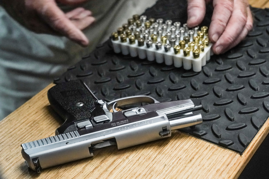 FILE - The owner of a shooting range prepares to load bullets in his 9mm semi-automatic handgun for a demonstration on June 23, 2022, in New York. (AP Photo/Bebeto Matthews, File)