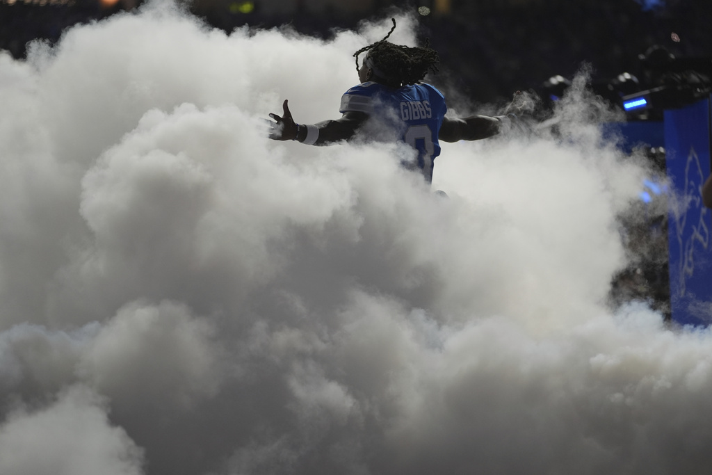 Detroit Lions running back Jahmyr Gibbs (0) runs through a cloud of smoke as he takes the field for an NFL football game against the Chicago Bears in Detroit, Sunday, Sept. 14, 2025. (AP Photo/Ryan Sun)