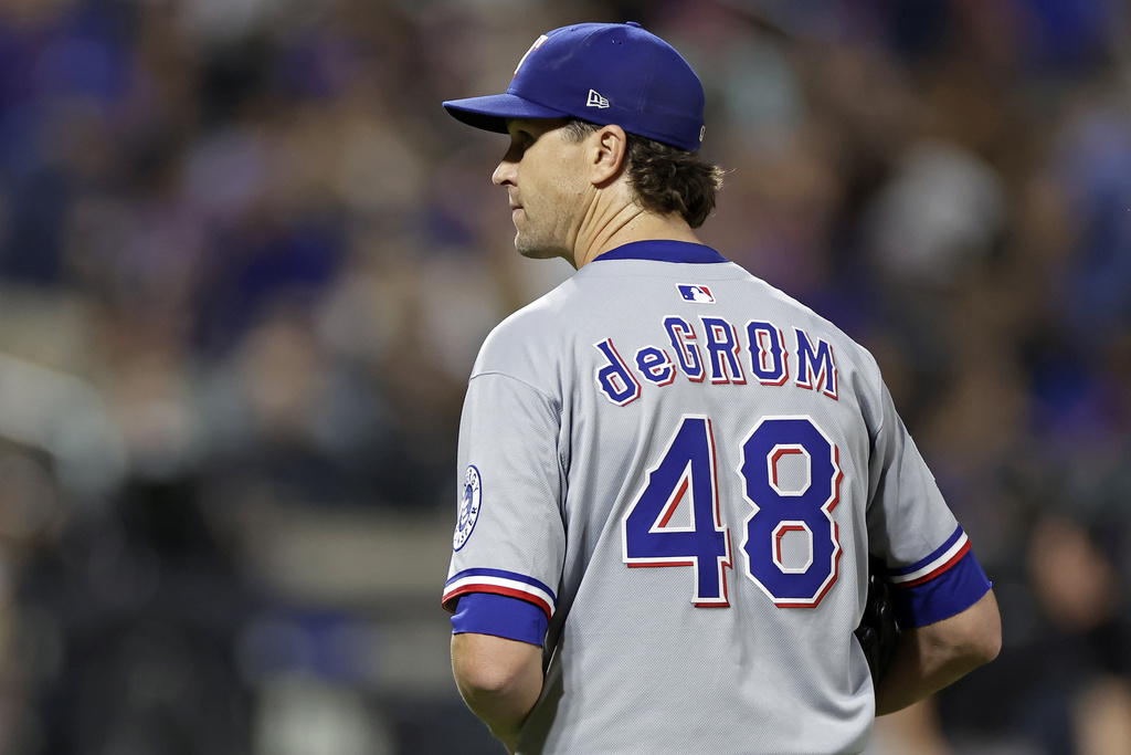 Texas Rangers pitcher Jacob deGrom looks towards the New York Mets dugout as he walks off the field after the sixth inning of a baseball game Friday, Sept. 12, 2025, in New York. (AP Photo/Adam Hunger)