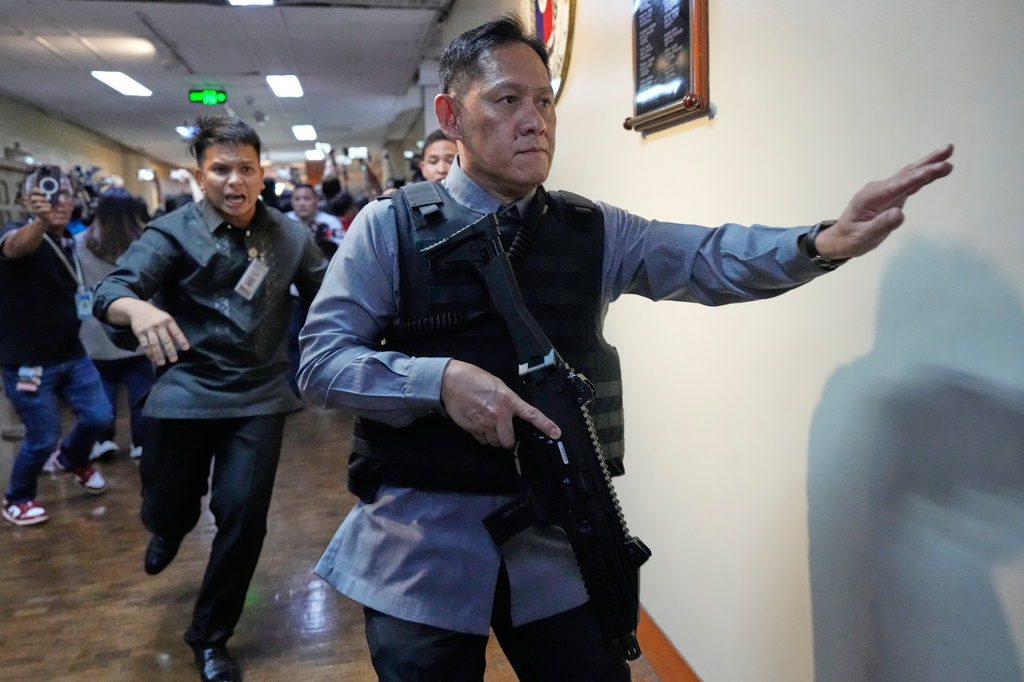 Senate security run after gunfire was heard along a hallway at the Philippine Senate in Pasay, Philippines, Wednesday, May 13, 2026. (AP Photo/Aaron Favila)