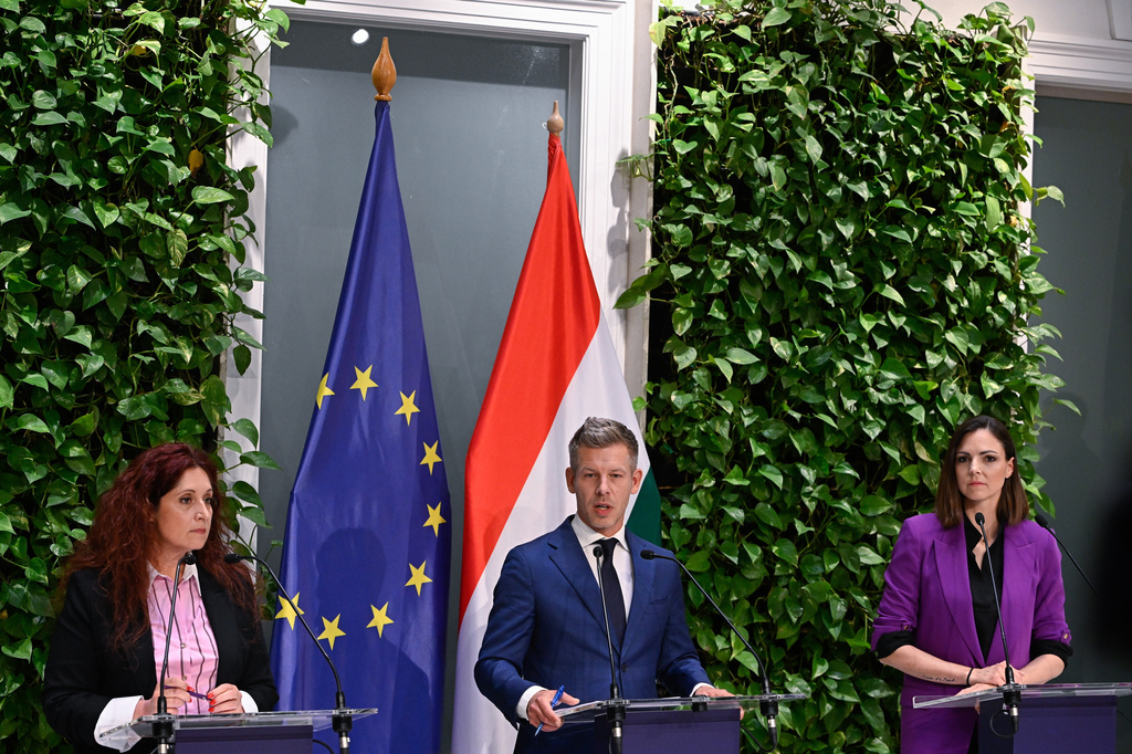 Hungarian Prime Minister Peter Magyar, center, stands between two of the government spokespersons Eva Magyar, left, and Anita Kobol, right, during a press conference following the meeting of the government in Budapest, Hungary, Monday, May 18, 2026. (Robert Hegedus/MTI via AP)