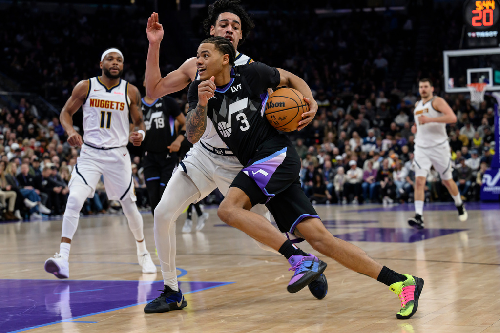 Utah Jazz guard Keyonte George (3) drives to the basket guarded by Denver Nuggets guard Julian Strawther, center back, during the first half of an NBA basketball game, Monday, March 2, 2026, in Salt Lake City. (AP Photo/Tyler Tate)