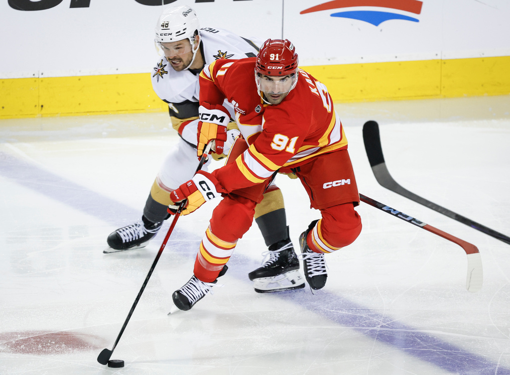 Vegas Golden Knights' Tomas Hertl, left, chases Calgary Flames' Nazem Kadri during third period NHL hockey action in Calgary on Tuesday, Oct. 14, 2025. (Jeff McIntosh/The Canadian Press via AP)