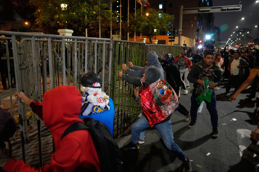 Demonstrators push a security railing near Congress during a protest against President Jose Jeri in Lima, Peru, Wednesday, Oct. 15, 2025. (AP Photo/Martin Mejia)