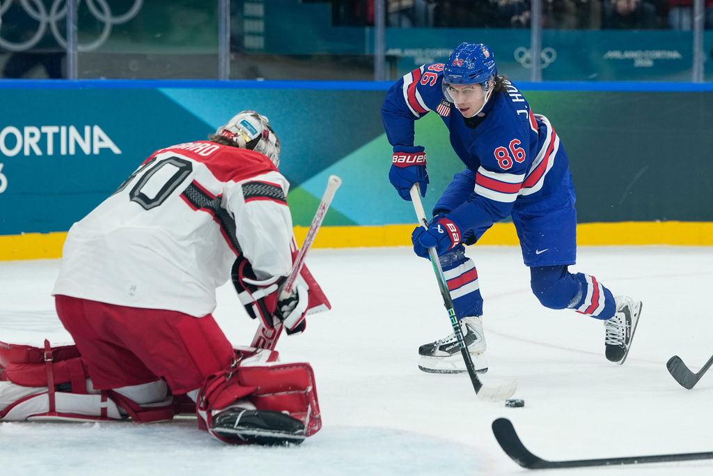 United States' Jack Hughes, right, shoots against Denmark's goalkeeper Mads Sogaard during a preliminary round match of men's ice hockey between United States and Denmark at the 2026 Winter Olympics, in Milan, Italy, Saturday, Feb. 14, 2026. (AP Photo/Petr David Josek)