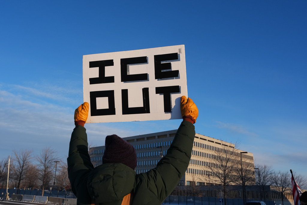 A protester holds up a sign outside the Bishop Henry Whipple Federal Building in Minneapolis, Saturday, Jan. 10, 2026. (AP Photo/Adam Gray)