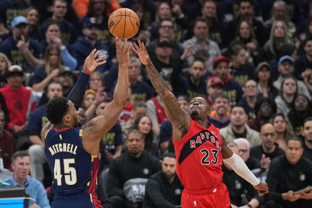 Cleveland Cavaliers guard Donovan Mitchell (45) shoots over Toronto Raptors guard Jamal Shead (23) in the first half in Game 2 of a first-round NBA basketball playoffs series in Cleveland, Monday, April 20, 2026. (AP Photo/Sue Ogrocki)