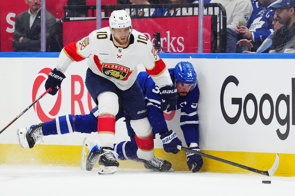 Florida Panthers' A.J. Greer (10) checks Toronto Maple Leafs' Auston Matthews (34) during first period NHL hockey action in Toronto on Tuesday, Jan. 6, 2026. (Frank Gunn/The Canadian Press via AP)