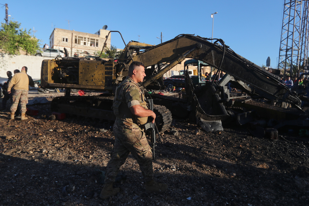 Lebanese army soldiers stand guard at a site that sold heavy machinery, where a large number of vehicles were destroyed in Israeli airstrikes, in the southern village of Msayleh, Lebanon, Saturday, Oct. 11, 2025. (AP Photo/Mohammed Zaatari)
