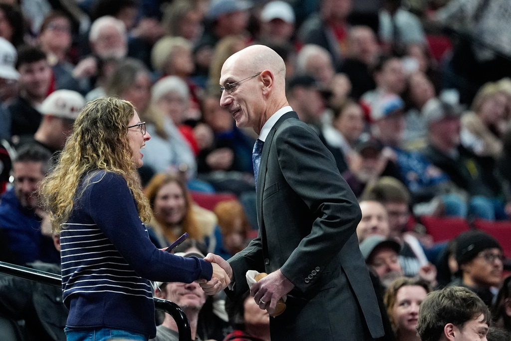 NBA commissioner Adam Silver greets a fan during an NBA basketball game between the Portland Trail Blazers and the Utah Jazz, Friday, March 13, 2026, in Portland, Ore. (AP Photo/Jenny Kane)