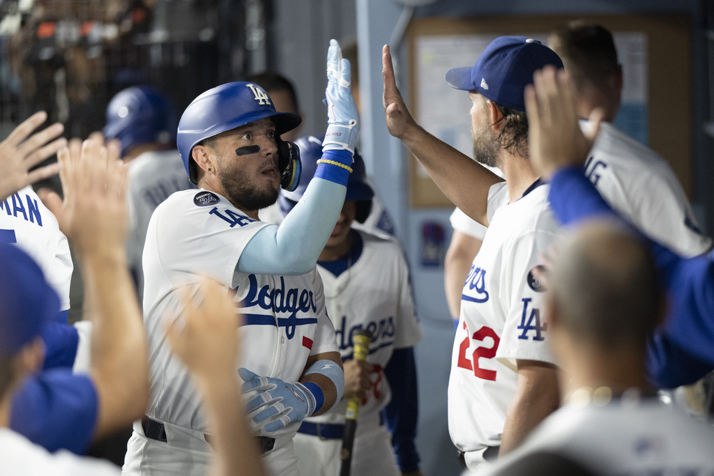 Los Angeles Dodgers' Miguel Rojas, left, celebrates his solo home run with Clayton Kershaw (22) during the second inning of a baseball game against the San Francisco Giants in Los Angeles, Friday, Sept. 19, 2025. (AP Photo/Kyusung Gong)
