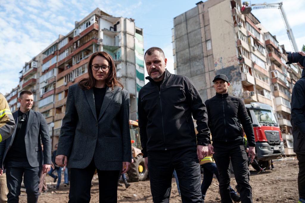 Ukraine's Prime Minister Yuliia Svyrydenko, left, and Ukraine's Interior Minister Ihor Klymenko, right, walk in the yard of an apartment building heavily damaged after a Russian strike on residential neighbourhood in Kyiv, Ukraine, on Friday, May 15, 2026. (AP Photo/Evgeniy Maloletka)