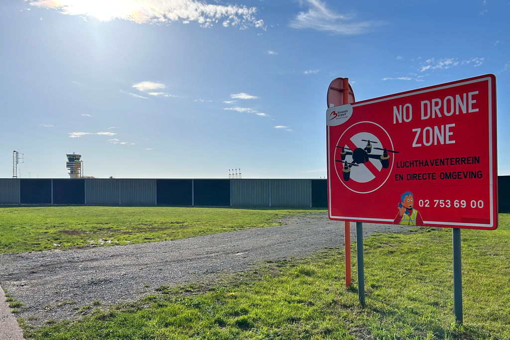 The control tower, left, and a no drone sign just outside the perimeter of Brussels International Airport in Zaventem, Belgium, after reported overnight drone activity over the airport, Wednesday, Nov. 5, 2025. (AP Photo/Virginia Mayo)