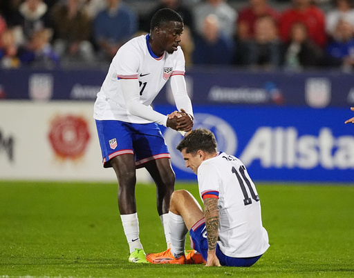 United States forward Tim Weah, left, helps up forward Christian Pulisic after he was injured against Australia in the first half of an international friendly soccer match Tuesday, Oct. 14, 2025, in Commerce City, Colo. (AP Photo/David Zalubowski) United States forward Tim Weah, left, helps up forward Christian Pulisic after he was injured against Australia in the first half of an international friendly soccer match Tuesday, Oct. 14, 2025, in Commerce City, Colo. (AP Photo/David Zalubowski)