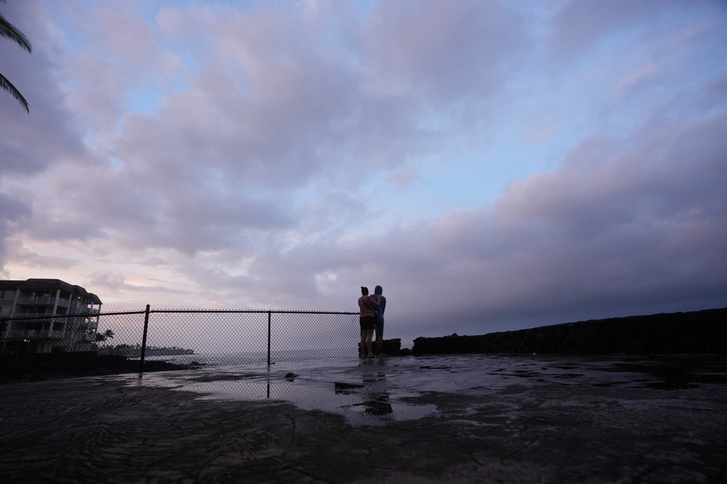 Ryanna and Jim Fry, of Kona, Hawaii, look out at clouds as Hurricane Nolo sits nearby Friday, Sept. 25, 2026, in Kona, Hawaii. (AP Photo/Gregory Bull)