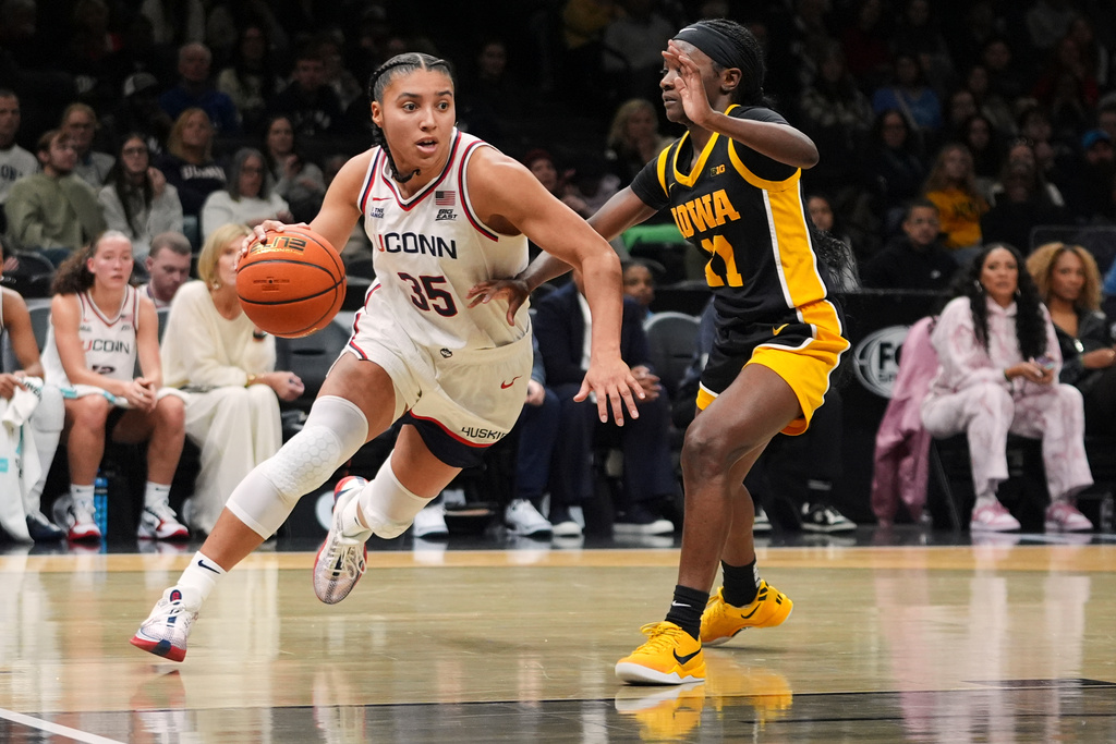 UConn's Azzi Fudd (35) drives past Iowa's Chazadi Wright (11) during the second half of an NCAA college basketball game Saturday, Dec. 20, 2025, in New York. (AP Photo/Frank Franklin II)