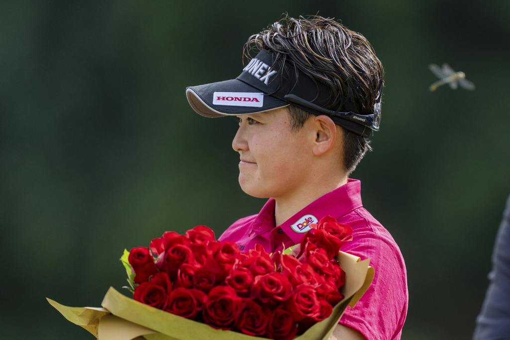 Akie Iwai, of Japan, holds a bouquet of flowers after winning the LPGA Portland Classic golf tournament at Columbia Edgewater in Portland, Ore., Sunday, Aug. 17, 2025. (AP Photo/Ali Gradischer)