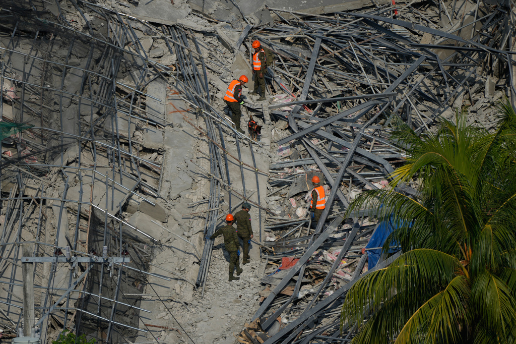 A K9 joins rescuers as they continue search operations at a collapsed building where multiple people are believed to be trapped in Angeles city in Pampanga province, north of Manila Monday, May 25, 2026. (AP Photo/Aaron Favila)