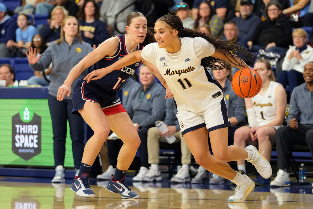 Marquette forward Skylar Forbes (11) dribbles against UConn guard Ashlynn Shade (12) during the first half of an NCAA college basketball game Saturday, Feb. 14, 2026, in Milwaukee. (AP Photo/Kayla Wolf)