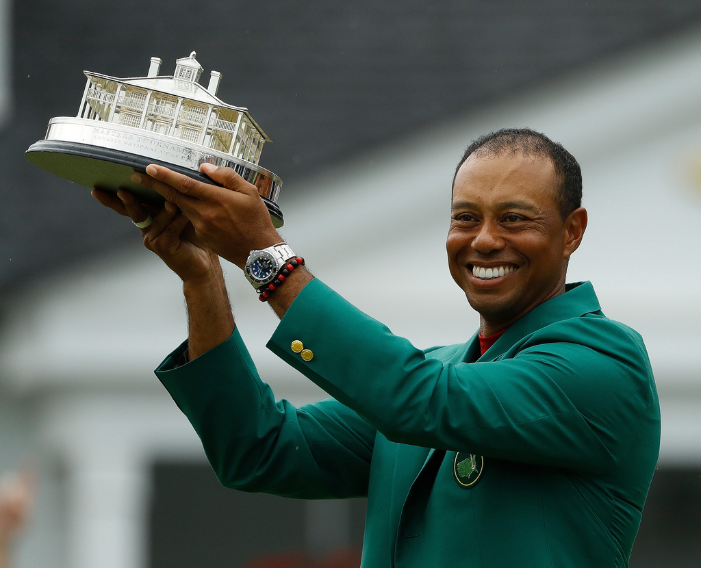 FILE - Tiger Woods wears his green jacket holding the winning trophy after the final round for the Masters golf tournament, Sunday, April 14, 2019, in Augusta, Ga. (AP Photo/Matt Slocum, File)