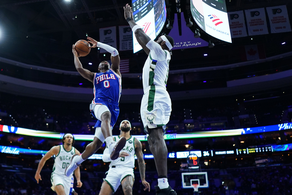 Philadelphia 76ers' Tyrese Maxey, left, goes up for a shot against Milwaukee Bucks' Bobby Portis during the first half of an NBA basketball game Tuesday, Jan. 27, 2026, in Philadelphia. (AP Photo/Matt Slocum)