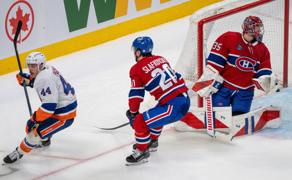 New York Islanders' Jean-Gabriel Pageau (44) beats Montreal Canadiens' Juraj Slafkovsky (20) to score on goaltender Samuel Montembeault (35) during the overtime of an NHL hockey game in Montreal, Thursday, Feb. 26, 2026. (Christinne Muschi/The Canadian Press via AP)