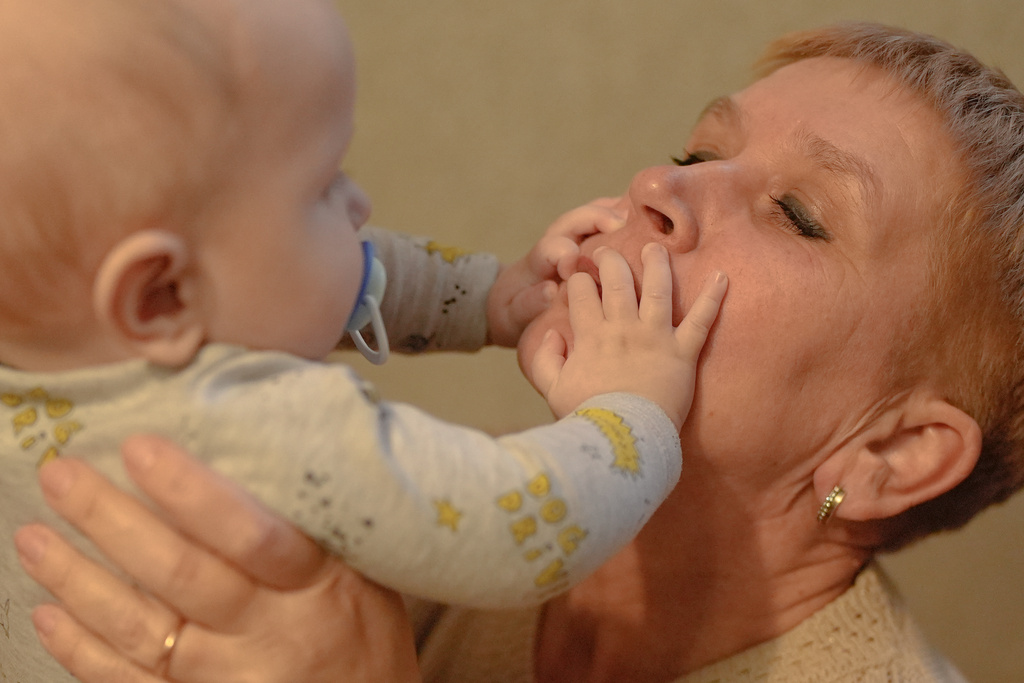 Tetiana, still wearing her wedding band, holds her grandson Demyan, who was born several months after Dmytro, his grandfather, was killed by a Russian strike on the Ukrainian thermal power plant where he worked, Wednesday, Oct. 29, 2025. (AP Photo/Julia Demaree Nikhinson)
