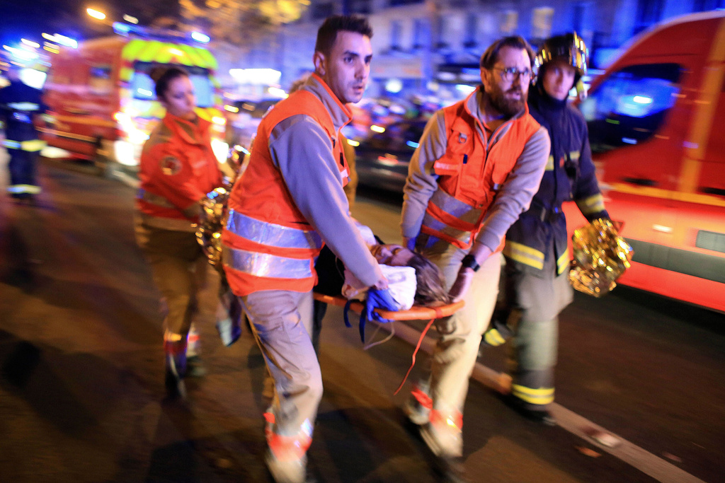 FILE - Medics evacuate a woman from the Bataclan concert hall after a shooting in Paris Nov. 13, 2015. (AP Photo/Thibault Camus, File)
