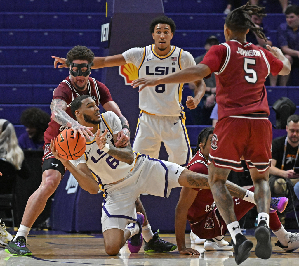 LSU forward Robert Miller III (6) works to maintain control of the ball under pressure by South Carolina guard Myles Stute (10) in the first half of an NCAA college basketball game in Baton Rouge, La., on Tuesday, Jan. 6, 2026. (Hilary Scheinuk/The Advocate via AP)
