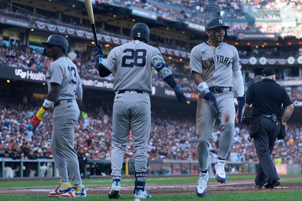 New York Yankees' Jazz Chisholm Jr., left, and José Caballero, right, are congratulated by Austin Wells (28) after both scored on Ryan McMahon's two-run single against the San Francisco Giants during the second inning of a baseball game in San Francisco, Wednesday, March 25, 2026. (AP Photo/Jeff Chiu)