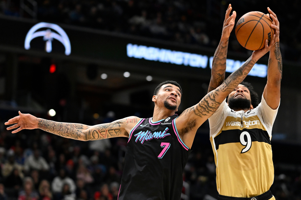 Miami Heat center Kel'el Ware (7) competes for a rebound against Washington Wizards forward Justin Champagnie during the first half of an NBA basketball game, Sunday, Feb. 8, 2026, in Washington. (AP Photo/John McDonnell)