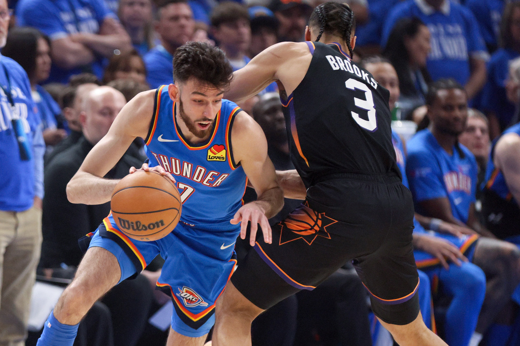 Oklahoma City Thunder center Chet Holmgren, left, drives against Phoenix Suns forward Dillon Brooks (3) during the first half in Game 1 of a first-round NBA playoffs basketball series Sunday, April 19, 2026, in Oklahoma City. (AP Photo/Nate Billings)
